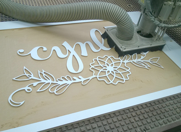 wooden Sign cutting for a tradeshow booth - Cynla Logo